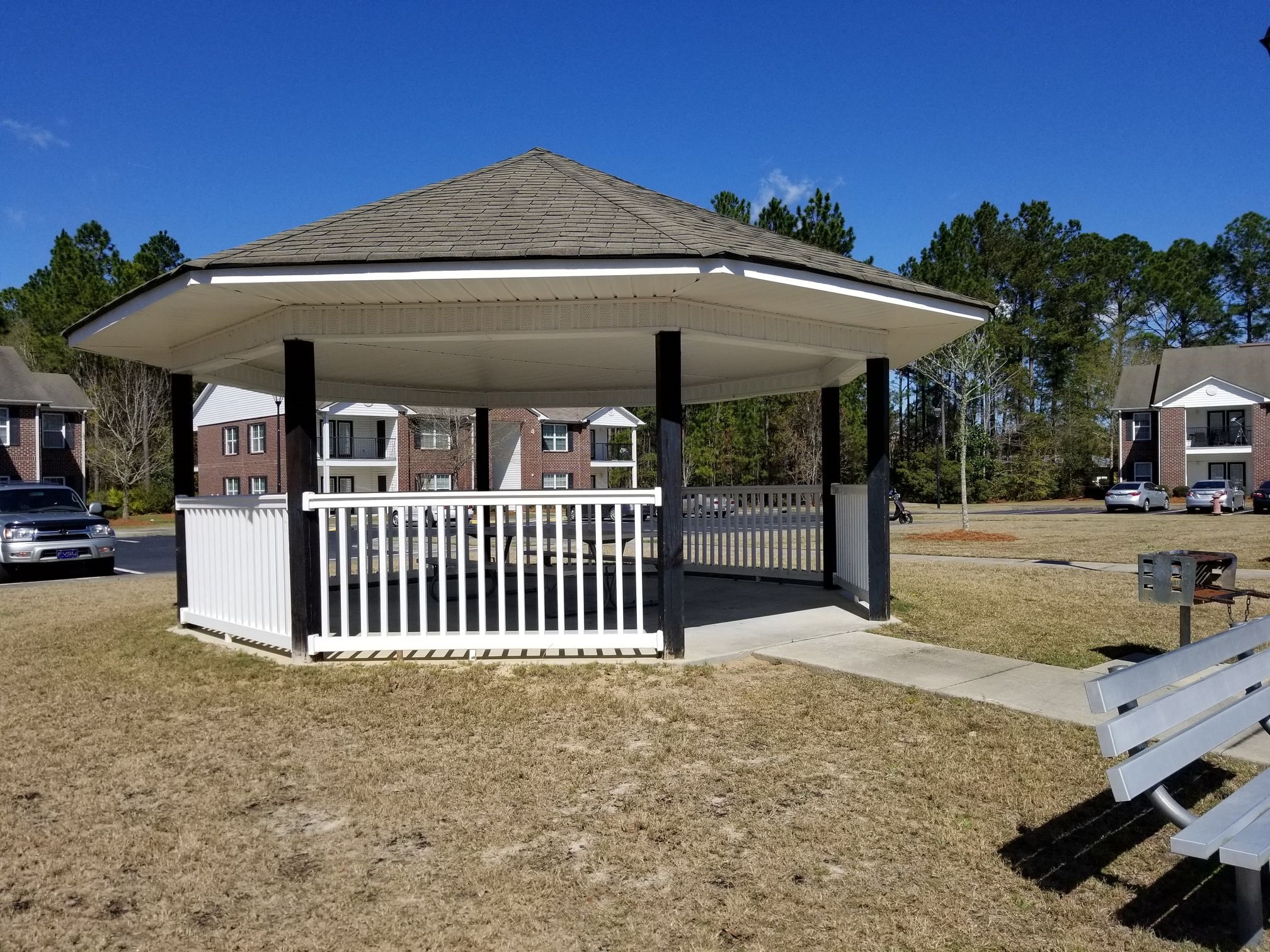 a gazebo with a white fence and a picnic table
